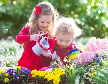 kids watering flowers in garden